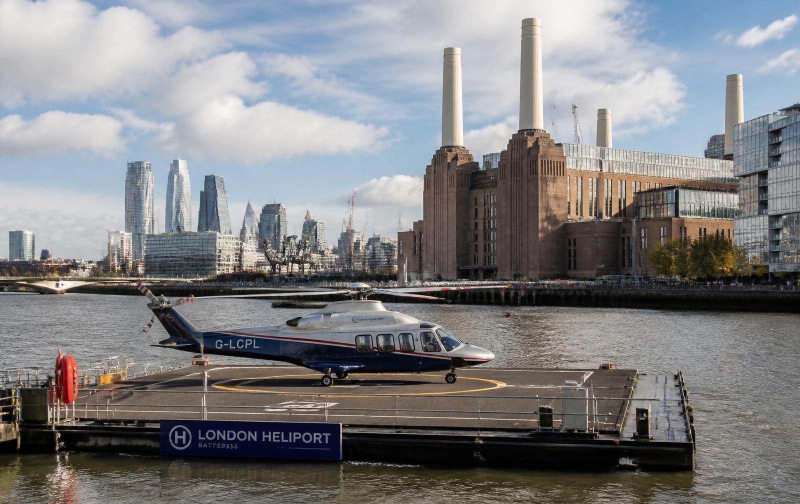 Helicopter on London Heliport pad on the Thames with Battersea Power Station behind and black Range Rover waiting