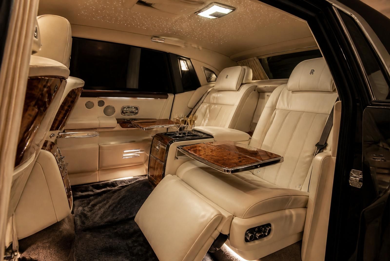 Rear cabin interior of a Rolls-Royce Phantom - cream leather, starlight headliner and chilled champagne
